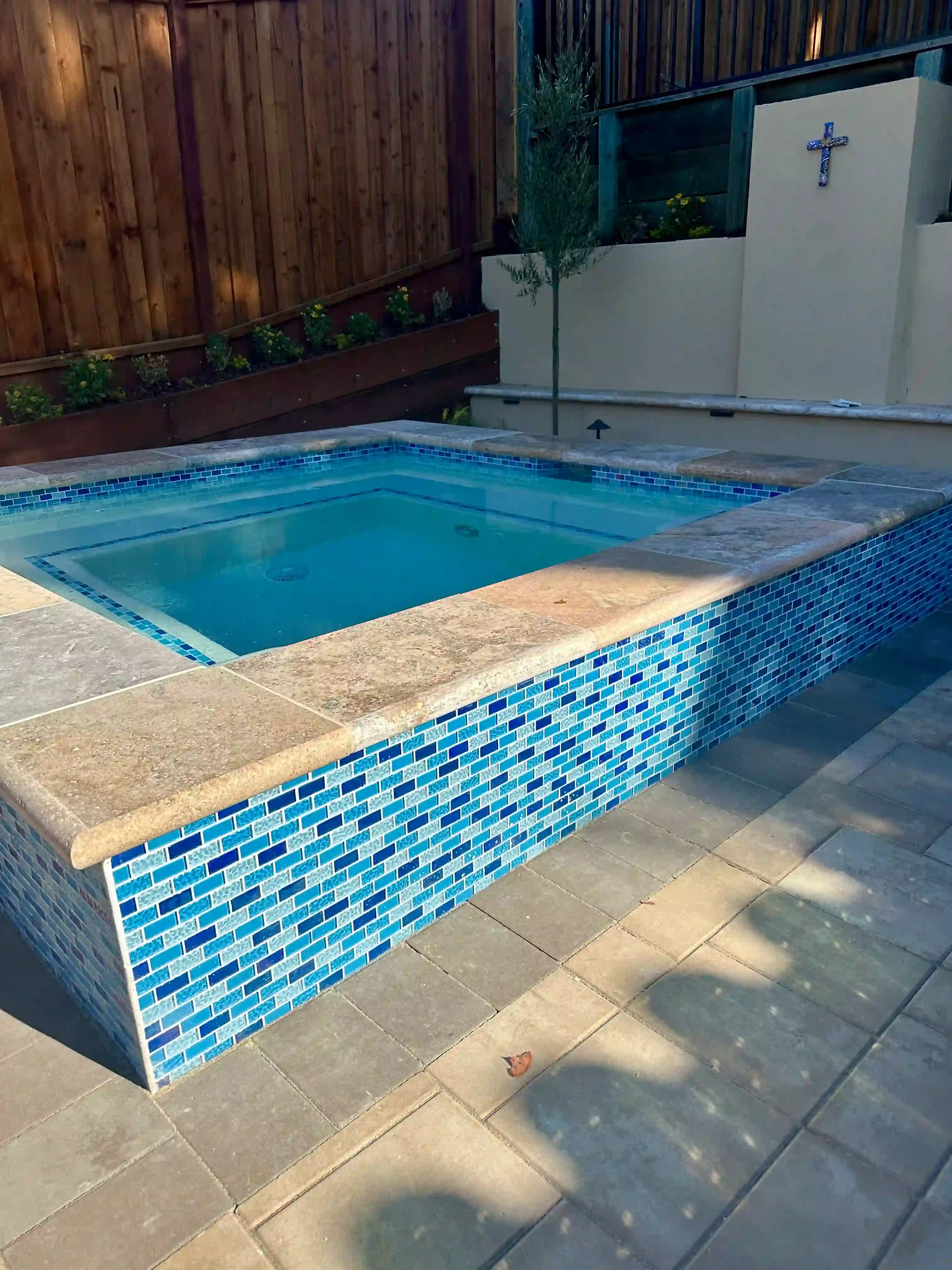 Stunning pool with waterfall feature and lush landscaping by Legendary Pools Inc.
