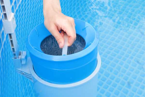 Hand testing pool water quality using a blue testing kit in a swimming pool, emphasizing maintenance for E. coli prevention and water safety. Hand testing pool water quality using a blue testing kit in a swimming pool, emphasizing maintenance for E. coli prevention and water safety.